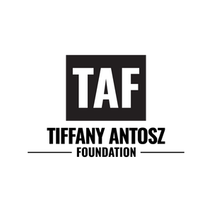 Tiffany Antosz Foundation logo in black and white. A black box with blocky white text reading "TAF" sits atop black text on a white background reading "Tiffany Antosz Foundation". Two black horizontal lines cap the word foundation. 